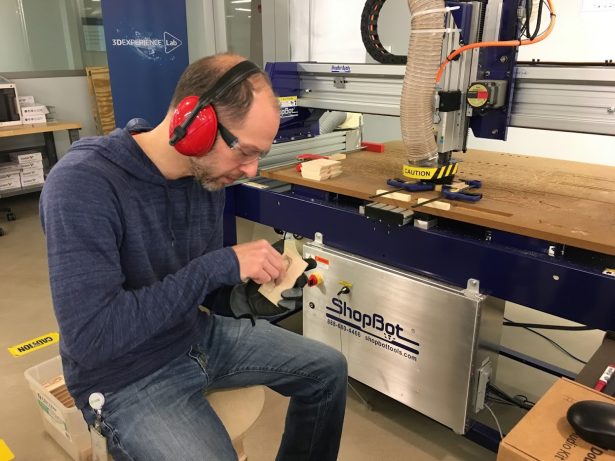 Sal working on the Cubie bases next to the CNC machine